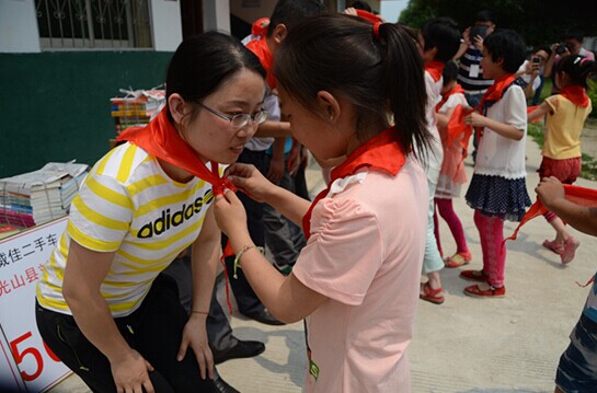 捐贈(zèng)儀式上，孩子們?yōu)閻坌奶焓瓜瞪霞t領(lǐng)巾