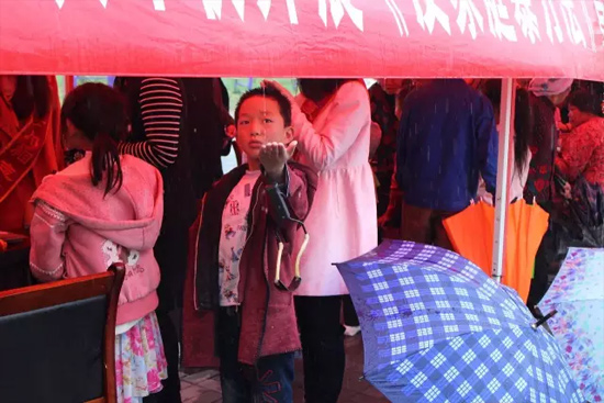 因?yàn)橛晗碌奶?，小男孩玩起了接水游戲? complete=