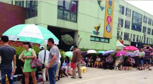 金壇市實(shí)驗(yàn)幼兒園門前，家長(zhǎng)在排隊(duì)