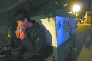 快遞哥抽空吃兩口東西。記者 李剛 攝