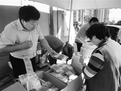 昨日，河南企業(yè)家劉春喜在京“練攤”，為顧客挑選綠豆。新京報(bào)記者 張玉學(xué) 攝