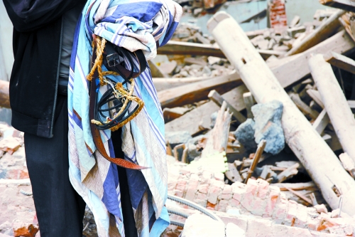 老人手中拿著曾控制住他的電線、床單