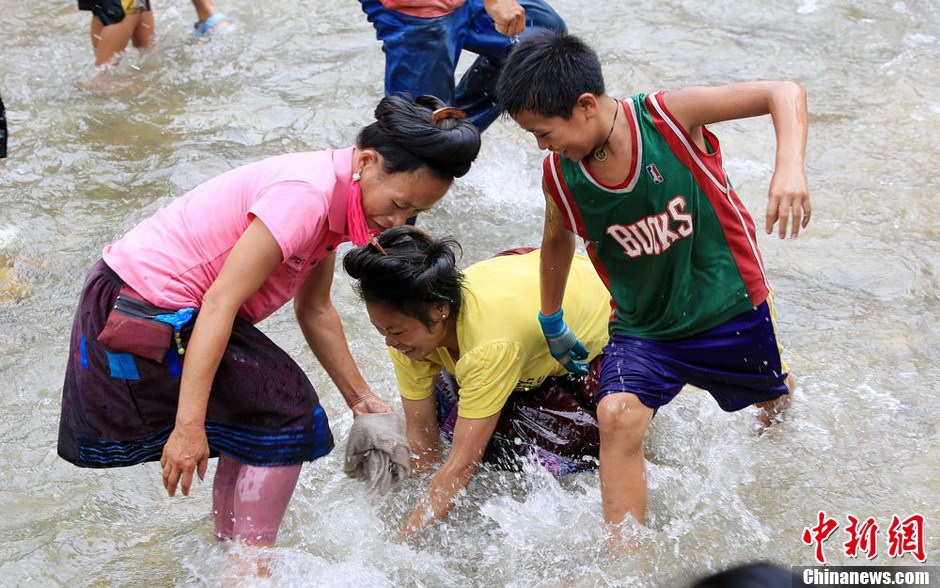7月9日，村民在小河里摸魚搶魚。譚凱興 攝