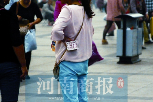 火車站廣場(chǎng)，一女子拿著寫有不同房型價(jià)位的卡片在拉客，不少市民抱怨，受過此類“騷擾”