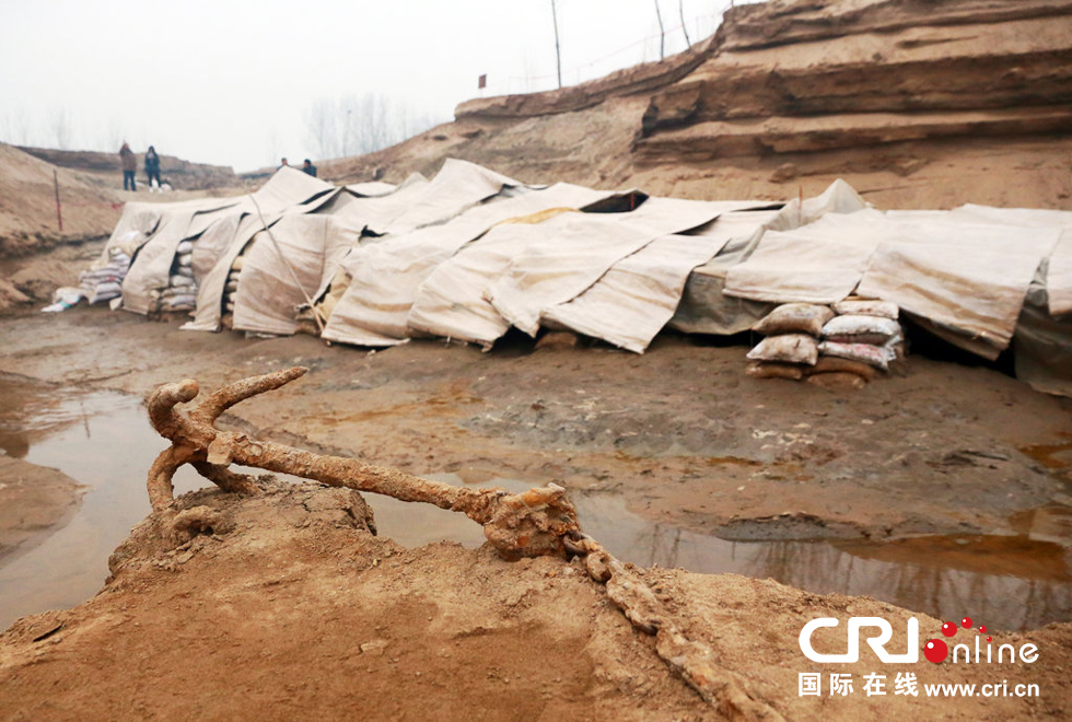 2014年1月6日，河南洛陽古沉船發(fā)掘現(xiàn)場，古沉船鐵錨從見天日，靜靜地躺在古船旁。