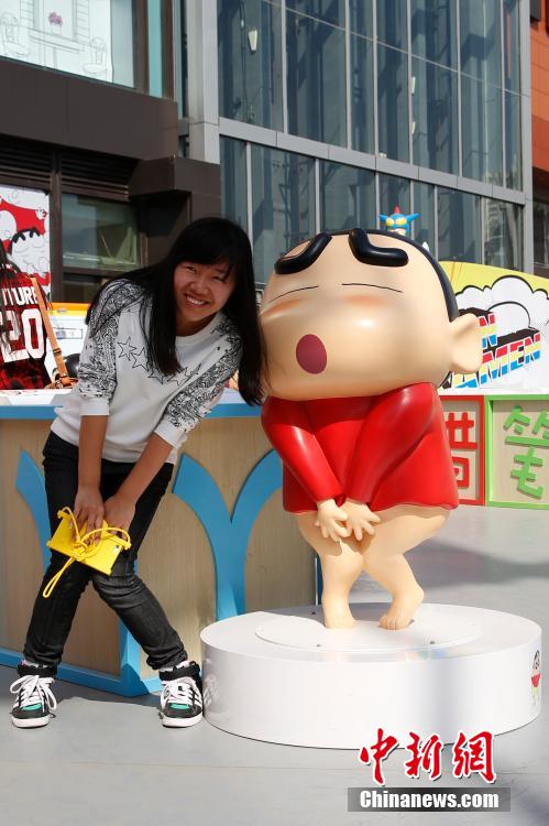 4月22日，游客與蠟筆小新合影?！跋灩P小新25周年紀(jì)念特展”日前在北京開展，吸引了不少市民游客。