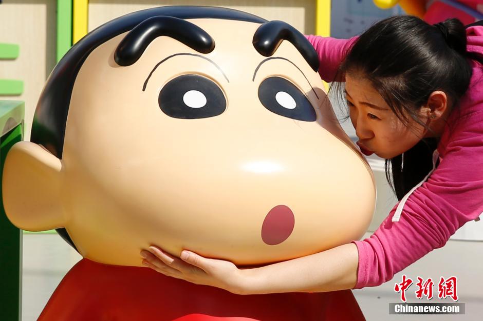 4月22日，游客與蠟筆小新合影?！跋灩P小新25周年紀(jì)念特展”日前在北京開展，吸引了不少市民游客。