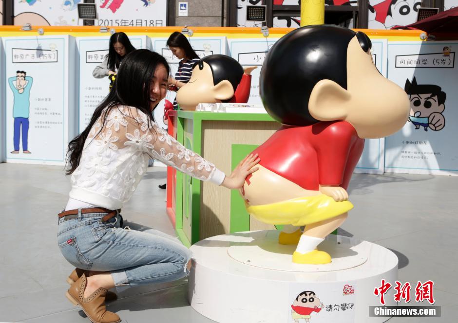 4月22日，游客與蠟筆小新合影。“蠟筆小新25周年紀(jì)念特展”日前在北京開展，吸引了不少市民游客。