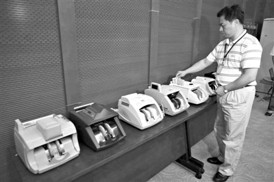 昨日，央行工作人員用各種驗鈔機(jī)對C1F9假幣進(jìn)行測試，機(jī)器均能及時作出異常報警反應(yīng)。新京報記者 浦