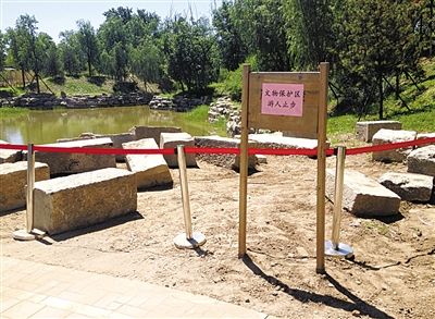 圓明園規(guī)月橋橋體構(gòu)件區(qū)域的警戒線和提示牌。 新京報記者 鄧琦 攝