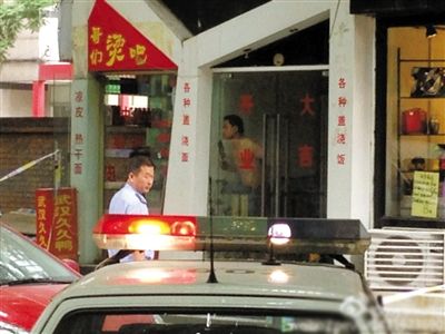 闖入面館的持刀男子與趕來的民警隔著玻璃門對峙，后店內(nèi)一名女童被其劫持。網(wǎng)友供圖