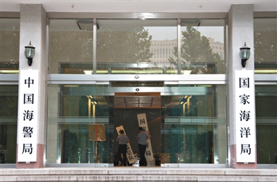 昨日，中國海警局掛牌成立。原國家海洋局和中國海監(jiān)總隊的牌匾被摘下，國家海洋局和中國海警局的新牌匾換上。黃冉 攝