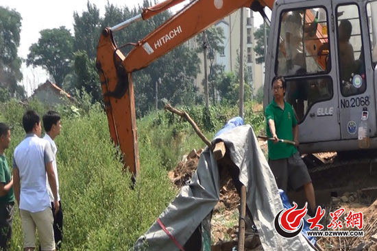 陳寶成手持自制刀斧守在挖掘機旁阻止便衣民警靠前。駕駛室內(nèi)，張朋珂正向受害人郭曉剛身上澆汽油。（視頻截圖）