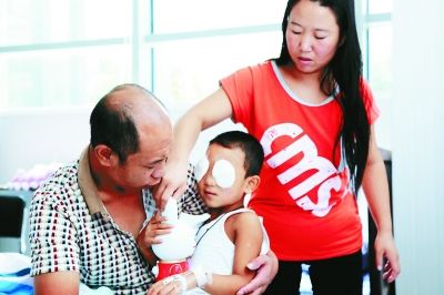 斌斌手術后第一天恢復良好，斌斌父母在用玩具逗他開心供圖/嚴益