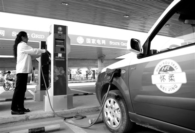 9月11日，懷柔區(qū)，電動(dòng)出租車司機(jī)正在為車輛充電。