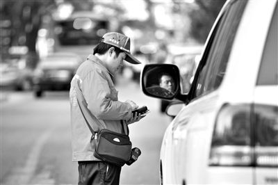 10月15日，朝陽區(qū)東大橋路，停車管理員從腰間掏出一個專用POS機，正在錄入停車信息。新京報記者 周崗峰 攝
