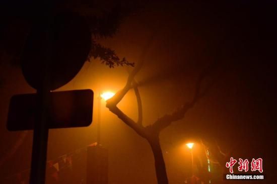 1月31日凌晨，市民行走在煙霧繚繞的南京街頭。當(dāng)天是農(nóng)歷馬年正月初一，南京有限開(kāi)禁燃放煙花爆竹正逢下霧天，空氣的不流通致使煙花爆竹燃燒后產(chǎn)生的顆粒物不能及時(shí)散開(kāi)，造成整座城市煙霧繚繞。據(jù)當(dāng)?shù)丨h(huán)保部門(mén)發(fā)布的信息顯示，空氣質(zhì)量屬重度污染。中新社發(fā) 泱波 攝