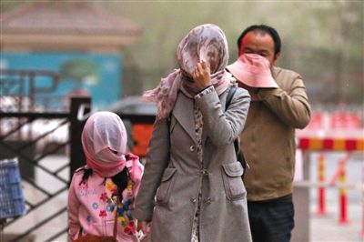 昨日下午，朝陽(yáng)區(qū)豆各莊，行人將紗巾裹在頭上防沙塵。