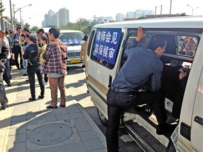 昨日，朝陽區(qū)看守所門前有人排隊。大門外還停有多輛寫有“律師會見”字樣的車。