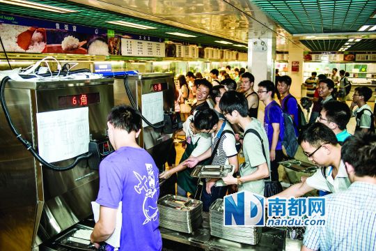 昨日，華南理工大學(xué)一食堂內(nèi)，學(xué)生們正在使用新安裝的自動打飯機打飯。中新社發(fā)
