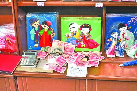 　　2012年6月21日，在朝鮮羅先特別市的一家商店里，柜臺上散落著一些人民幣。在朝鮮，人民幣比本國
