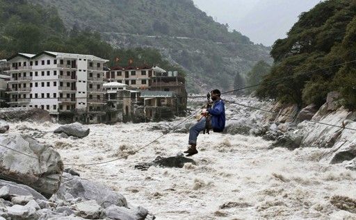 一名印度男子靠繩索渡河。