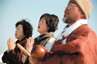 23日，一名僧侶引領(lǐng)人們?yōu)樗勒咂矶\。