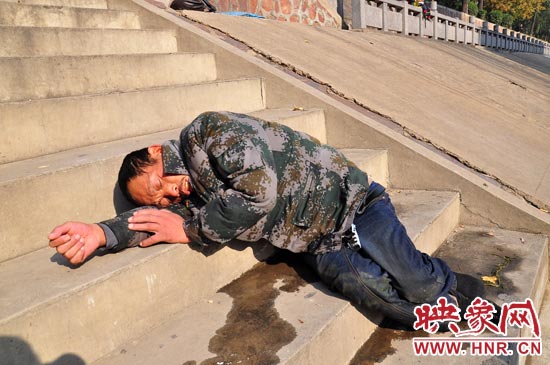 這名男子的衣服以及褲子全濕透了，水從衣褲里流出來，嘴里散發(fā)著濃烈的酒氣。