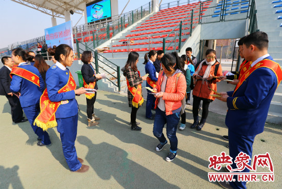 活動(dòng)現(xiàn)場(chǎng)工作人員給同學(xué)們發(fā)放宣傳冊(cè)、環(huán)保袋。