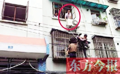 施救現(xiàn)場，劉鵬（圈內(nèi)）先用繩子捆住老太確保安全 勞動報記者 郭娜 供圖