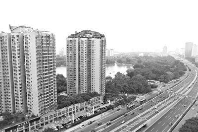 昨日，人濟山莊小區(qū)，與其他樓相比，B棟樓頂層天臺上違規(guī)建造了一棟兩層小樓，假山大樹俱全。新京報記者