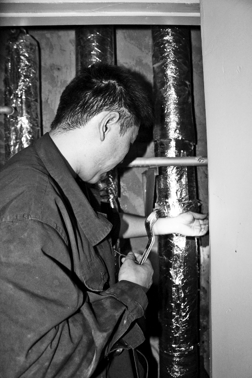 苗師傅一邊進(jìn)行維修，一邊用耳機(jī)接聽市民的電話。