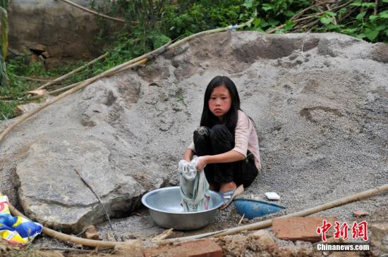 8月9日，云南巧家紅石巖村，10歲的劉鑫蕊在洗自己的衣服