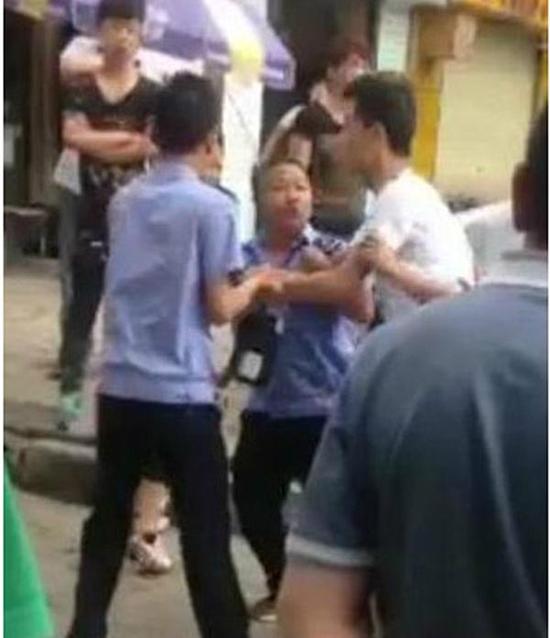 付某（右）與城管執(zhí)法人員廝打在一起。