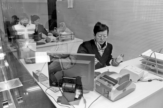 2月16日，鄭州市自來水總公司鄭東新區(qū)一營業(yè)廳，柜臺(tái)內(nèi)工作人員正在為市民辦理業(yè)務(wù)