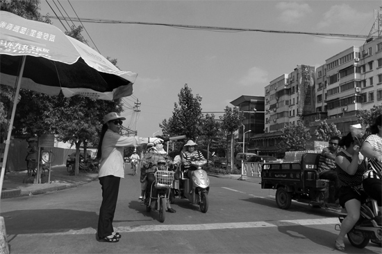 昨日，開封市區(qū)一名協(xié)管員在指揮群眾過馬路