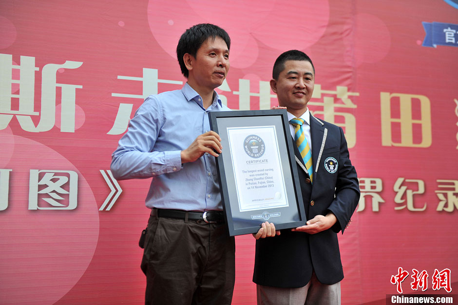 圖為世界吉尼斯認(rèn)證官為鄭春輝（左）頒發(fā)證書。呂明 攝