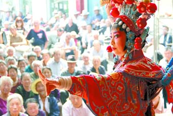 圖為8月15日戲曲演員在“流動(dòng)舞臺(tái)車”上表演傳統(tǒng)地方戲《穆桂英下山》。