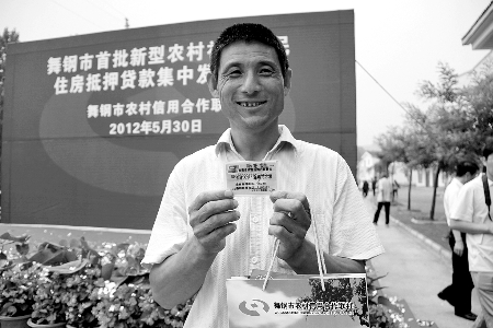 領(lǐng)到貸款，農(nóng)民開心地笑了。