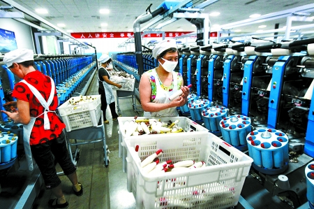 6月6日，舞鋼市鑫海紡織有限公司員工正在新建成的紡紗車間生產(chǎn)。