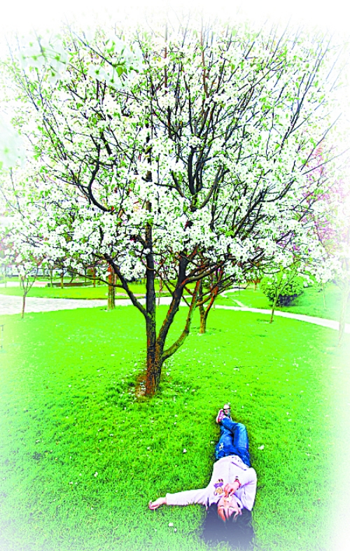 　孩子愜意地躺在社區(qū)內的草坪上。