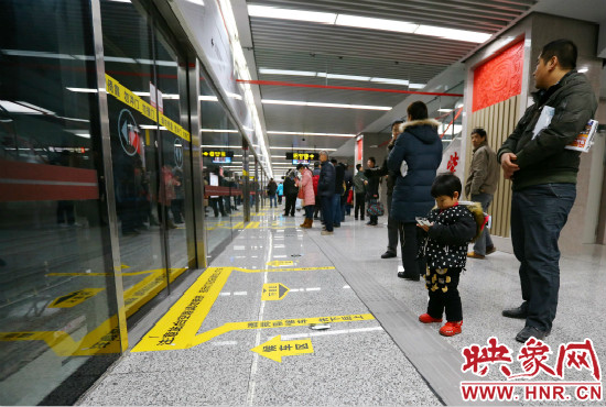 小朋友在等候區(qū)內(nèi)等待地鐵。