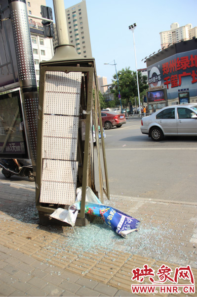 路旁的路燈箱已經(jīng)被肇事車(chē)輛撞碎。