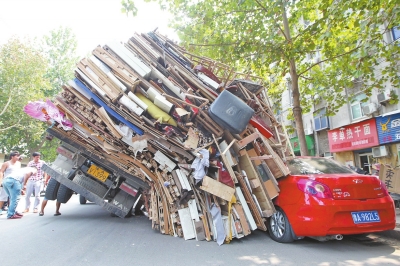 紅色小轎車被砸，卡在路邊動彈不得。