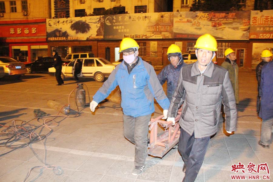 23點(diǎn)56分，第一塊兒廣告牌已經(jīng)分割完畢，地面上的20多名工人將拆除下來的鋼件撞車運(yùn)走。