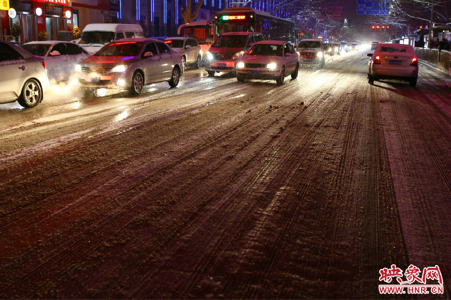 夜晚的雪路給出行的人們增加了困難。