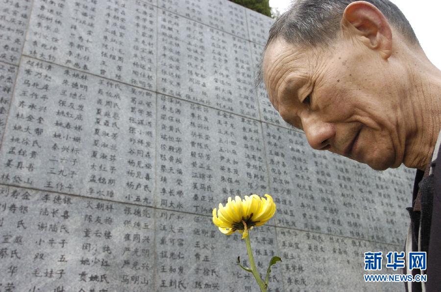 2006年4月5日，74歲的南京大屠殺幸存者佘子清手捧鮮花，祭奠被日軍殺害的母親。