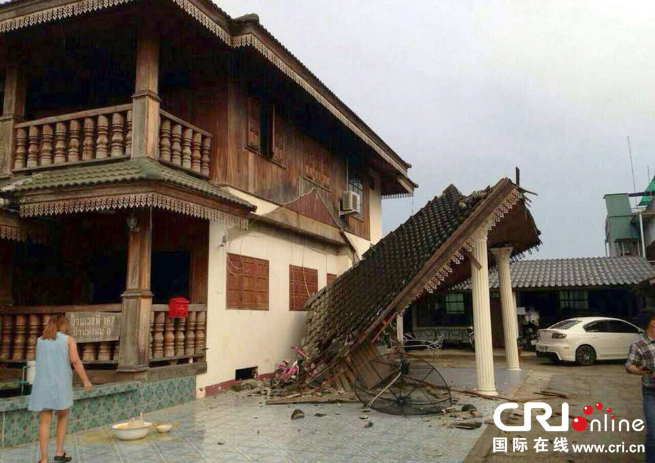 當(dāng)?shù)貢r(shí)間2014年5月5日，泰國(guó)清萊，一名婦女看著受損的房屋。 圖片來(lái)源：東方IC