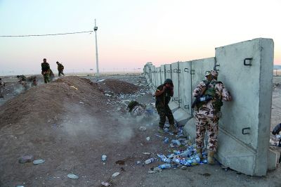 埃爾比勒郊外的一個檢查站附近,武裝組織成員躲避在掩體后 埃爾比勒郊外的一個檢查站附近,武裝組織成員躲避在掩體后