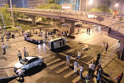 路虎沖下國(guó)貿(mào)橋砸中一輛起亞轎車，橋上厚達(dá)幾十厘米的水泥護(hù)欄被撞斷，碎石四處散落，數(shù)十群眾在現(xiàn)場(chǎng)圍觀。